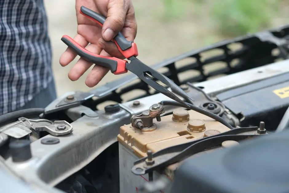 Batterie 12V posée sur un établi, multimètre affichant la tension à ses côtés